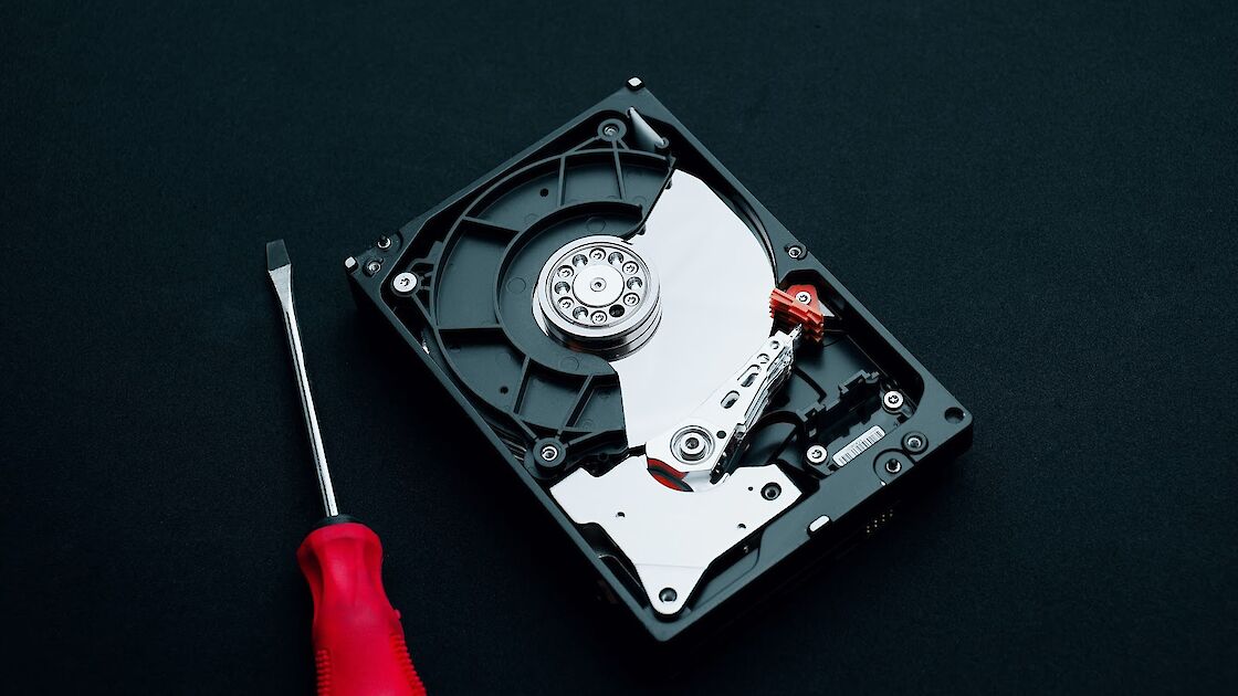 Hard disk drive with a screwdriver sitting next to it