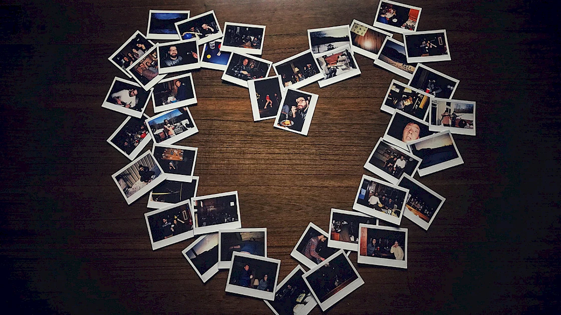 photographs on a table, arranged in a heart shape