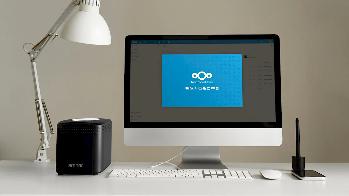 A desktop computer with Nextcloud running in the browser, hosted by on the AmberPRO device beside it.