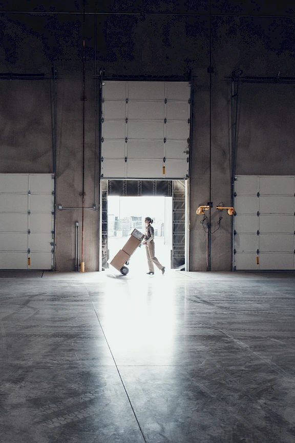 A woman is seen in a warehouse alone with boxes